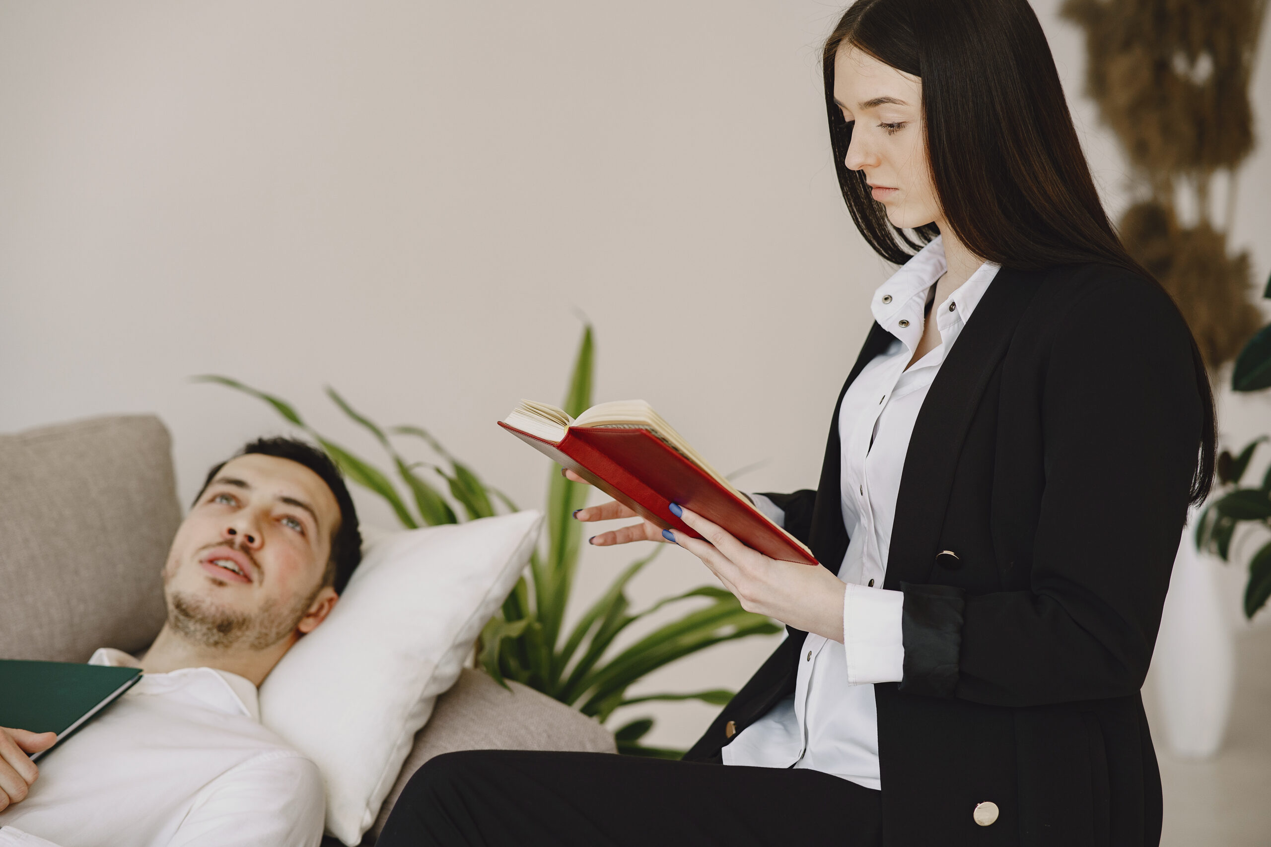 In the psychologist's office. Man and woman talking. Brunette in a white shirt.